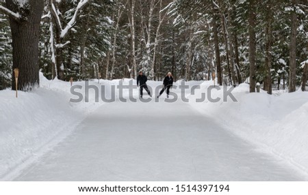 A man and a woman on a liesurely skate on the forest trail through Arrowhead Park in Ontario