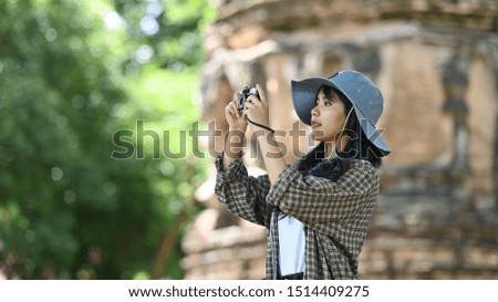 Young woman traveler using camera in archaeological site