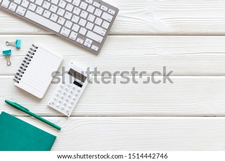 Creative work desk with green supplies on white wooden backround flat lay copy space top view