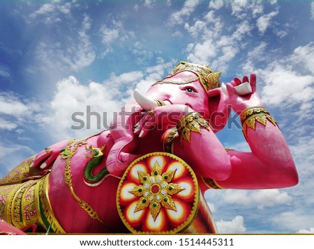 Wat Saman Rattanaram, Buddhist temple in Thailand. Giant pink statue of a Hindu god. Semi-sitting, reclining side With his left hand holding a broken tusk Right hand holding a lotus flower.