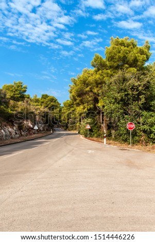 Road on the Croatian island of Lastovo. Forest junction with stop road sign. Morning on the road. Holiday in Croatia.