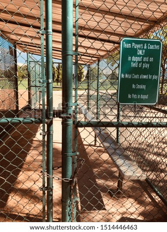 A Baseball Dugout Behind a Green Fence.