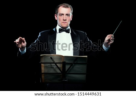 Studio photo of music conductor holding his baton Royalty-Free Stock Photo #1514449631