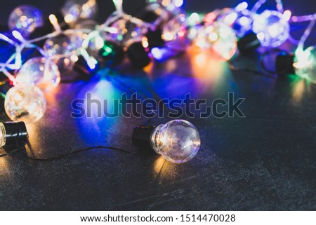 one unique lightbulb metaphor of good idea standing out from the crowd with group of others in the background with psychedelic lights, shot at shallow depth of field