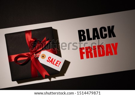 Top view of black christmas boxes with red ribbon on black background with copy space for text. black Friday and Boxing Day composition.