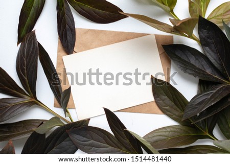 mockup card with plants. invitation card with envelope and details Mockup with postcard and flowers on white background.