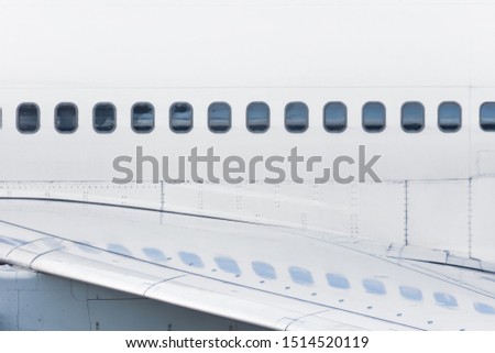 View of the fuselage of the aircraft and many windows, with reflection on the wing Royalty-Free Stock Photo #1514520119