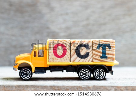 Truck hold letter block in word oct on wood background (Concept for month October)