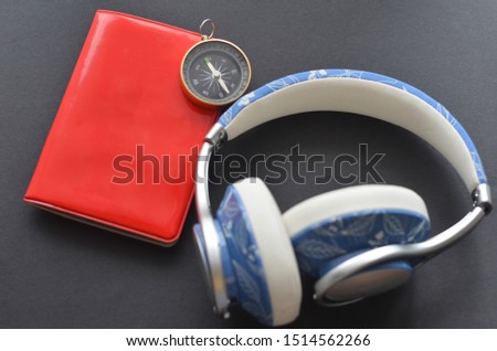 Travel concept : Compass, headphone and passport on black background.