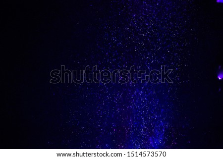 Colorful powder/particles fly after being exploded against black background
