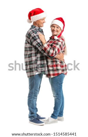 Portrait of happy mature couple in Santa Claus hats on white background