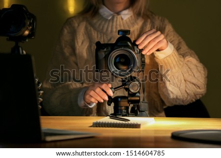 Female photographer working at table in evening, closeup