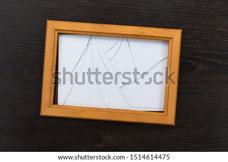 Broken glass photo frame on a wooden table