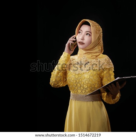 A beautiful business muslim woman is talking with her customer via mobile phone.