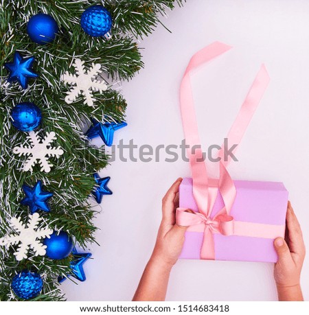 Child hands holding one gift box wrapped in kraft paper tied ribbon . Top view, place for text. Holiday concept