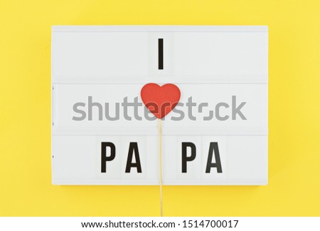 I love papa text on white lightbox with wooden heart on yellow background. Greeting card concept to celebrate Father's day