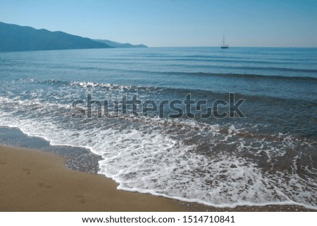 sandy beach, blue mountains, blue sea, yacht, wave