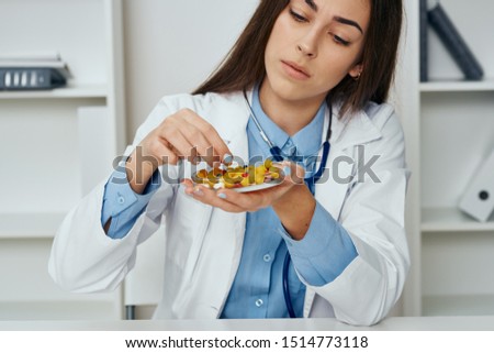  Medical coat blue shirt beautiful woman doctor and multi-colored pills                              
