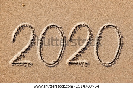 new year 2020 written in sand 