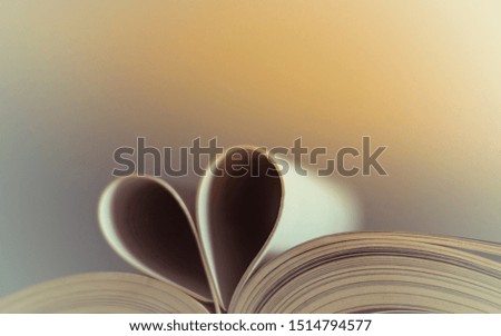Close-up picture of the book opened, which the book sheet rolled into a heart shape selective focus and shallow depth of field