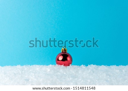 Winter background with snow and Christmas bauble decoration. Minimal Christmas or New Year concept.