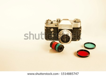 Old retro camera, color lens mock up blank white background. Closeup interior home white poster mockup with space for text. Retro template for poster, picture. White table, blank space, vintage camera