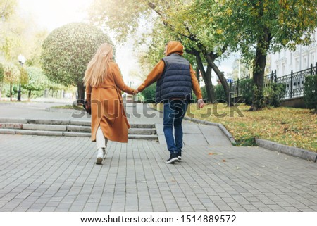 Happy young couple in love teenagers friends dressed in casual style walking together on the city street in cold season