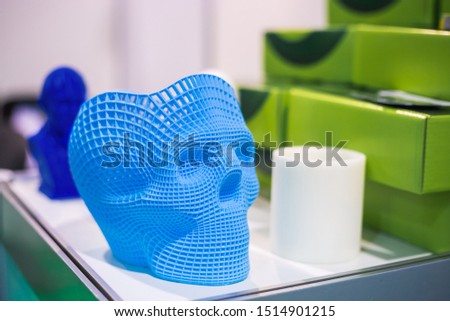 Plastic model of abstract blue human skull at modern technology exhibition. 3D printing, additive technologies and futuristic concept