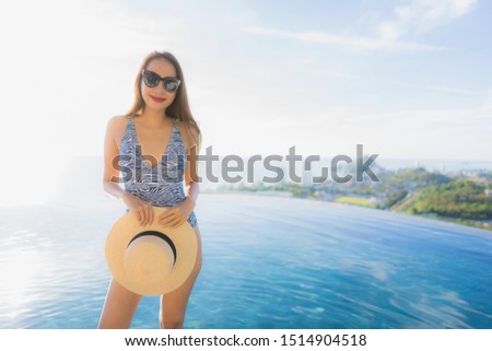 Portrait beautiful young asian woman smile happy relax around swimming pool in hotel resort with sea and ocean view for leisure travel in holiday vacation