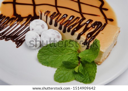 Cheesecake with mint leaves on a plate on a gray background