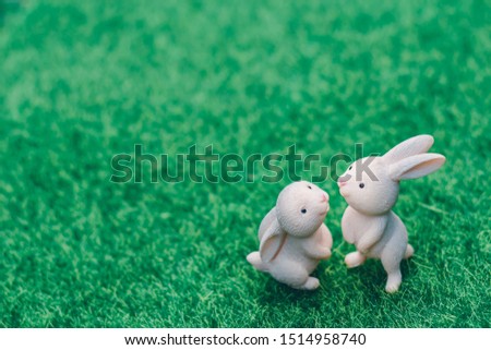 Cute rabbit doll stand alone on the natural green background, Morning sunshine, Selective focus,Vintage Style, Easter Festival.