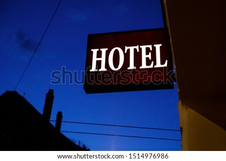 Illuminated sign "hotel" on the street.