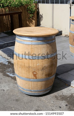 a large wooden barrel stands on a city street
