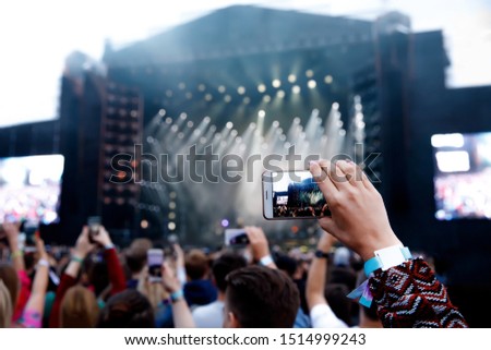 Smartphone over the crowd at a music concert. Record light show