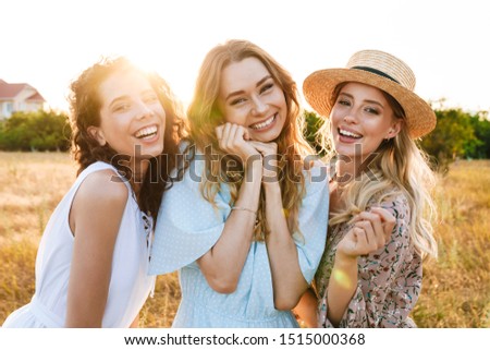 Photo of joyful beautiful women smiling and looking at camera on countryside during sunny day