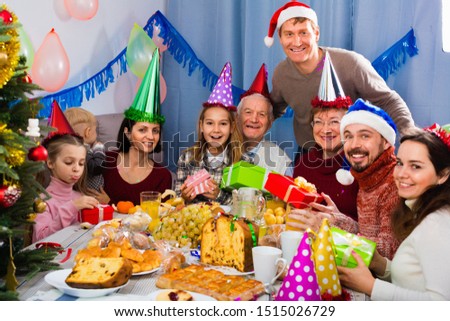 Cheerful positive  family exchanging gifts during Christmas dinner