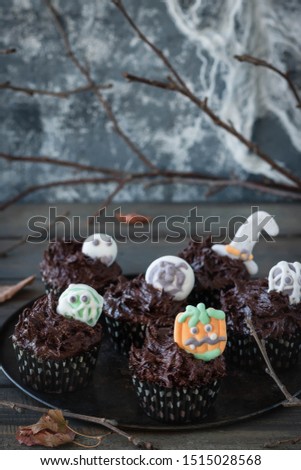Chocolate Cupcakes with Chocolate Cream Decorated with Creepy Marshmallow Sweets for Halloween Party. Halloween food.