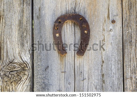 Metal horseshoe hanging on wooden door
