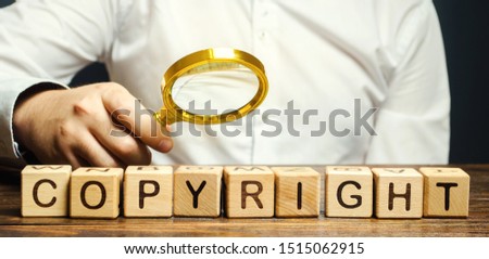 Businessman puts wooden blocks with the word Copyright. Patenting. Copyright protection. Brand and patent. The fight against online piracy.