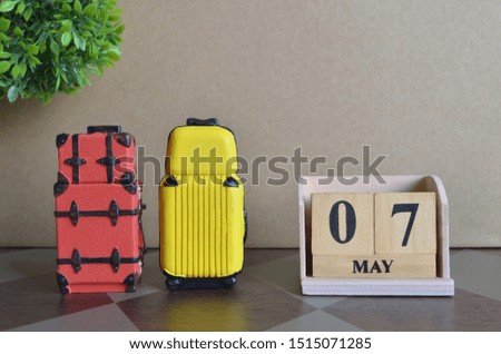 Appointment Date 7, May, Holiday, Travel cover with number cube and luggage.