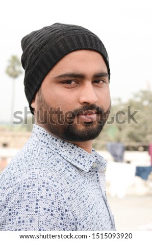 Young Indian man having black beard and wearing woolen hat in Winter season.