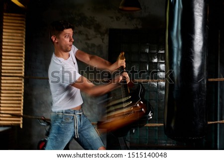the guitarist has a guitar for a punching bag and shouting in anger