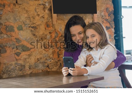 Mom and daughter enjoy social networks on mobile phone