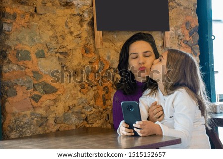 Mom and daughter enjoy social networks on mobile phone