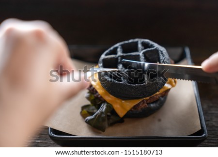 Black charcoal burger beef , cheese, unhealthy food or junk food Cause obesity.