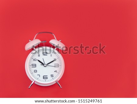 White Alarm Clock on bright red background.
