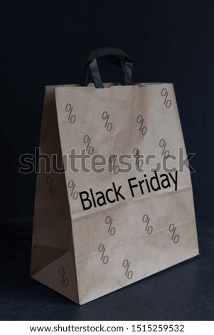 Black Friday paper bag on black background. Promotional concept.