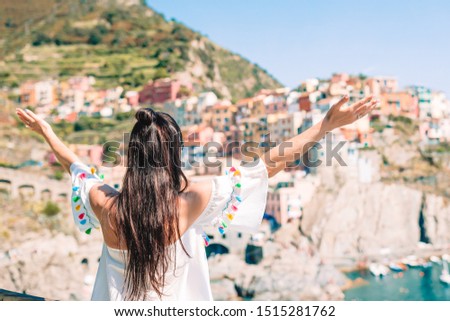 Back view of happy girl background beautiful view of Manarola, Cinque Terre, Liguria, Italy