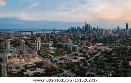 Aerial panoramic view of Toronto city skyline with streets, roads, infrastructure, residential areas and parks at dusk. Shot with drone. 