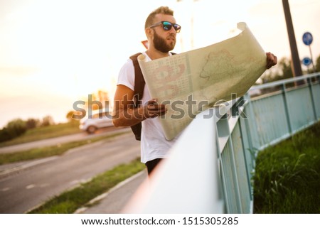 A lost tourist in the city with a map in his hands